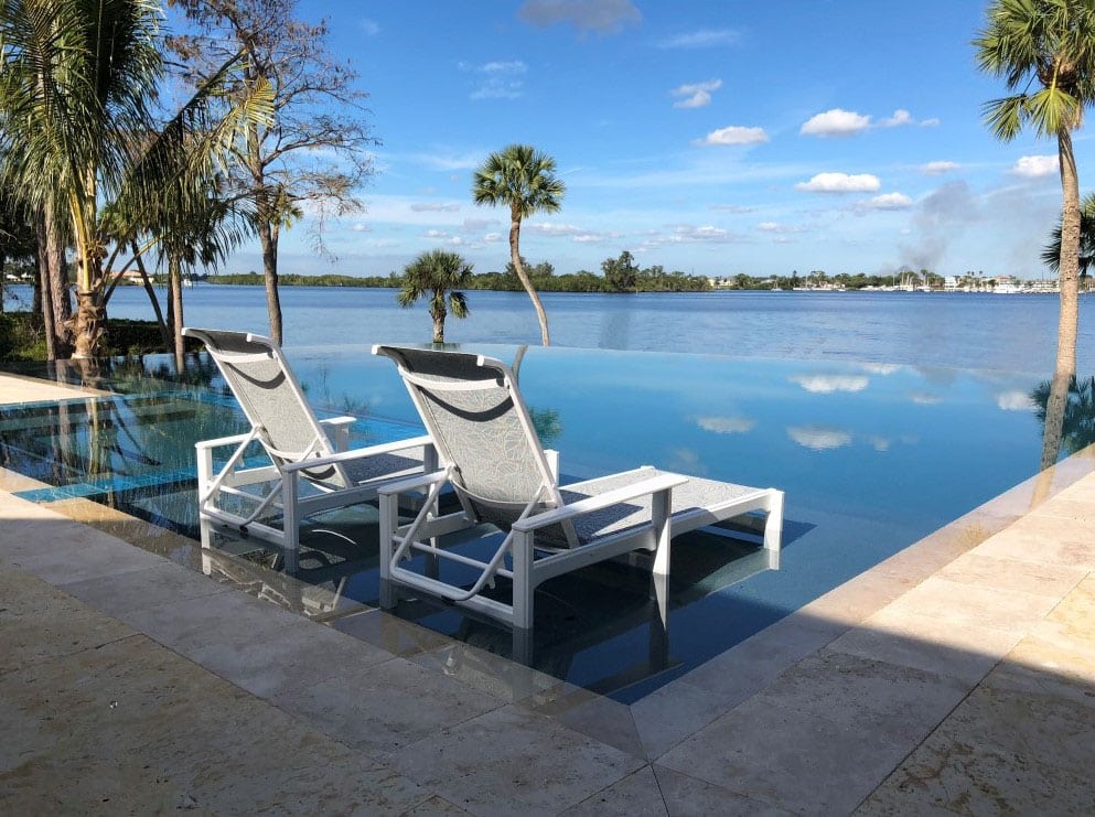 Beachside spillover pool with in-pool lounge area overlooking water.